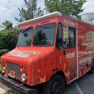 a red food truck parked in a parking lot