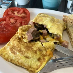 Northern omelette with mushrooms, ham and cheddar. Side of tomatoes and toast.
