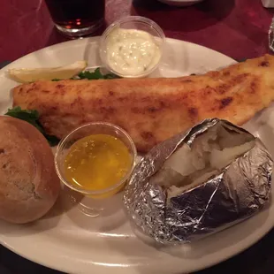 Perfectly cooked Walleye fillet with baked potato and hard roll.