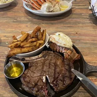 Ribeye steak with a side of lobster tail and snow crab legs