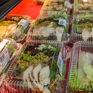 a variety of salads in plastic containers
