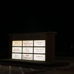 a lighted sign in a parking lot