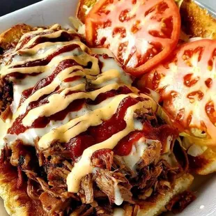 a pulled pork sandwich with tomato and cheese