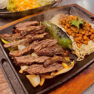 Skillet beef fajitas with herb rice, charro beans and all the fixings.