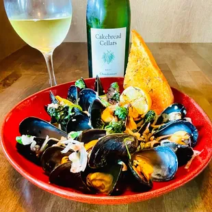 Special: mussels delicately cooked in a rich garlic herb butter sauce, accompanied by shallots, scallions, pickled ginger, and fresh spinach