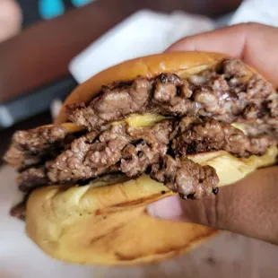 a hand holding a beef sandwich
