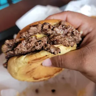 a person holding a sandwich in their hand