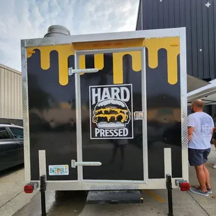 a man standing in front of a trailer