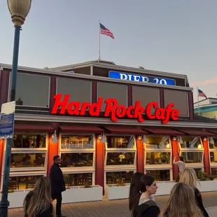 people walking in front of a hard rock cafe