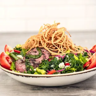 a plate of salad with meat and vegetables