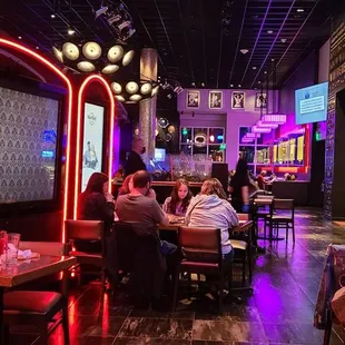 people sitting at tables in a dimly lit restaurant