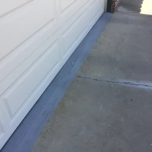 Unrequested garage floor paint extended over cold joint to driveway plus unrequested, unsightly patch over driveway crack.
