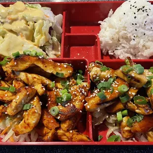 Bento box with teriyaki chicken and spicy chicken.