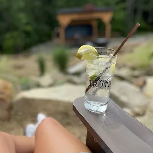 a woman sitting on a bench with a drink
