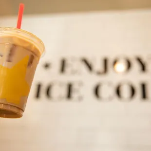 a hand holding a cup of iced coffee