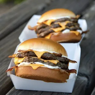 two hamburgers with cheese and bacon