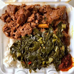 a styrofoam container filled with meat, greens, rice, and