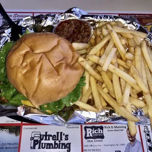 Cheeseburger with pickle and lettuce with an order of fries