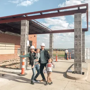 a family standing in front of a building under construction