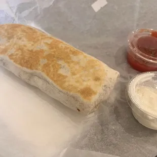Loaded breakfast burrito with a side of salsa and sour cream
