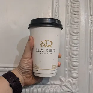 a hand holding a coffee cup
