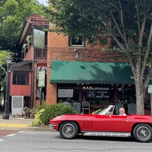 a man driving a red sports car