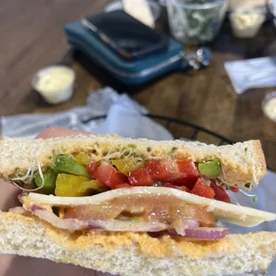 a person holding a sandwich