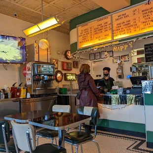 a woman standing at a counter in a diner