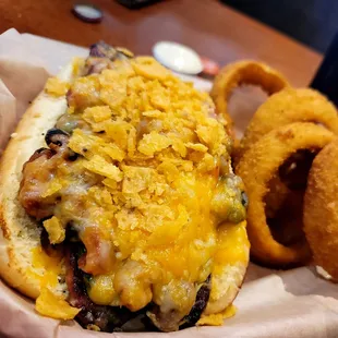 a hot dog with cheese and onion rings