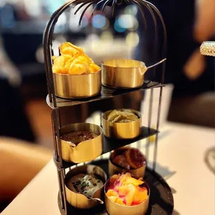 The accoutrements to the caviar service in a birdcage.