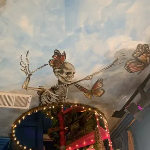 a painted ceiling with a skeleton and butterflies