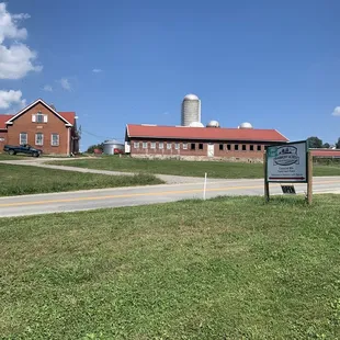 a farm with a sign and a barn