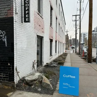 a sign on a sidewalk in front of a building