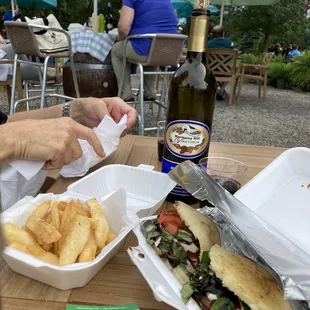 a woman eating a sandwich and french fries