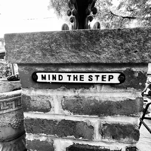 mind the step sign on a brick wall