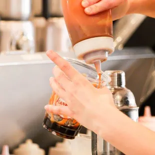 Crafting a fresh-made Caramel Milk Tea.