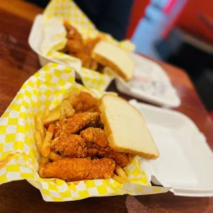 two baskets of fried chicken and french fries