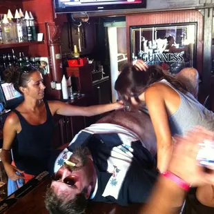 Yeah, that is a hairy heavy guy laying on the bar and his GF attempting a shot off his hairy pasty white belly.