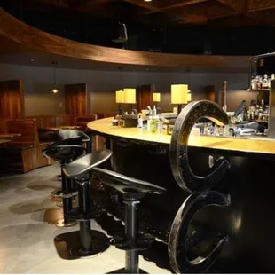 a bar with stools and tables