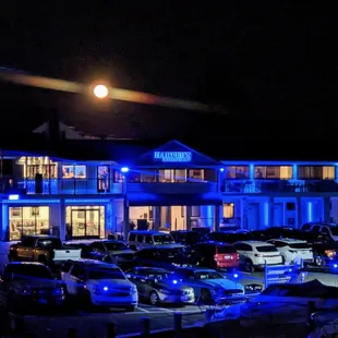 cars parked in front of a hotel at night