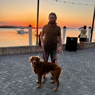 a man and his dog at sunset