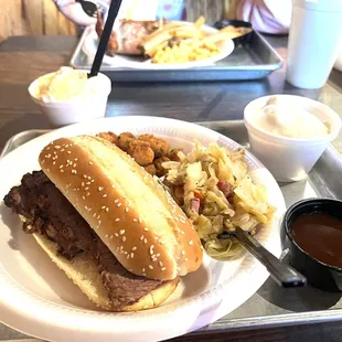 Sliced beef, cabbage, okra, mashed potatoes.. chicken in the background with fries and Mac