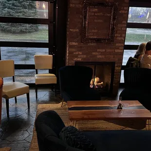 two people sitting in front of a fireplace