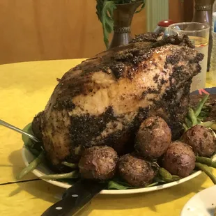 a roast turkey on a plate with potatoes and asparagus