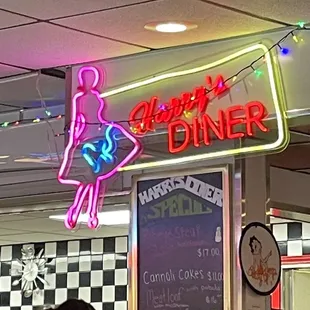 the neon sign for harry&apos;s diner