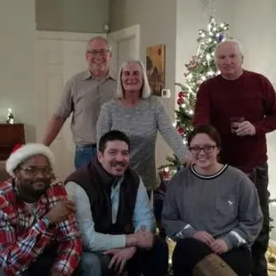 a group of people in front of a christmas tree