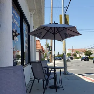 a table and chairs with an umbrella