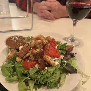 a plate of salad and a glass of wine