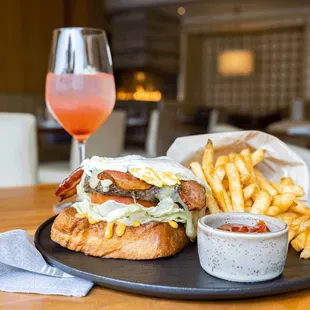 Brunch Burger: open-faced brioched french toast, beef patty, smoked bacon, white cheddar, harissa aioli, lettuce, tomato,  egg, french fries