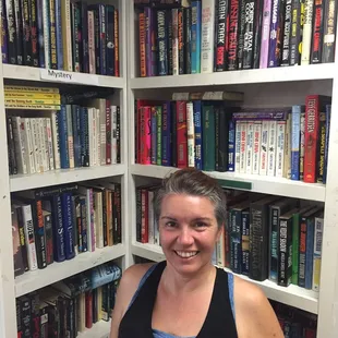 Barbara Rogers in front of a portion of the Mystery section